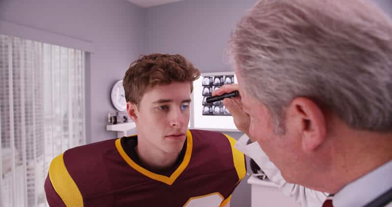 football player being examined by a doctor for a concussion