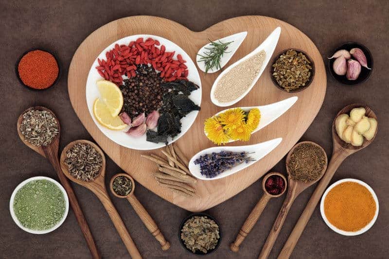 healthy nuts, grains, beans, and spices on a heart platter