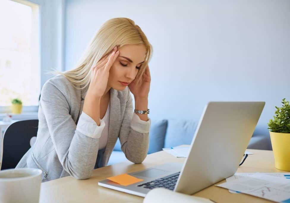 woman with a headache at her computer